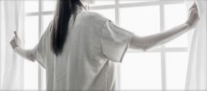 カーテンを開ける女性